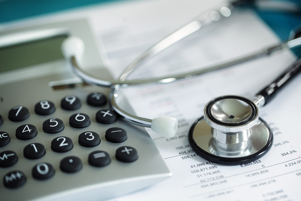 Balance sheets with a stethoscope and a calculator