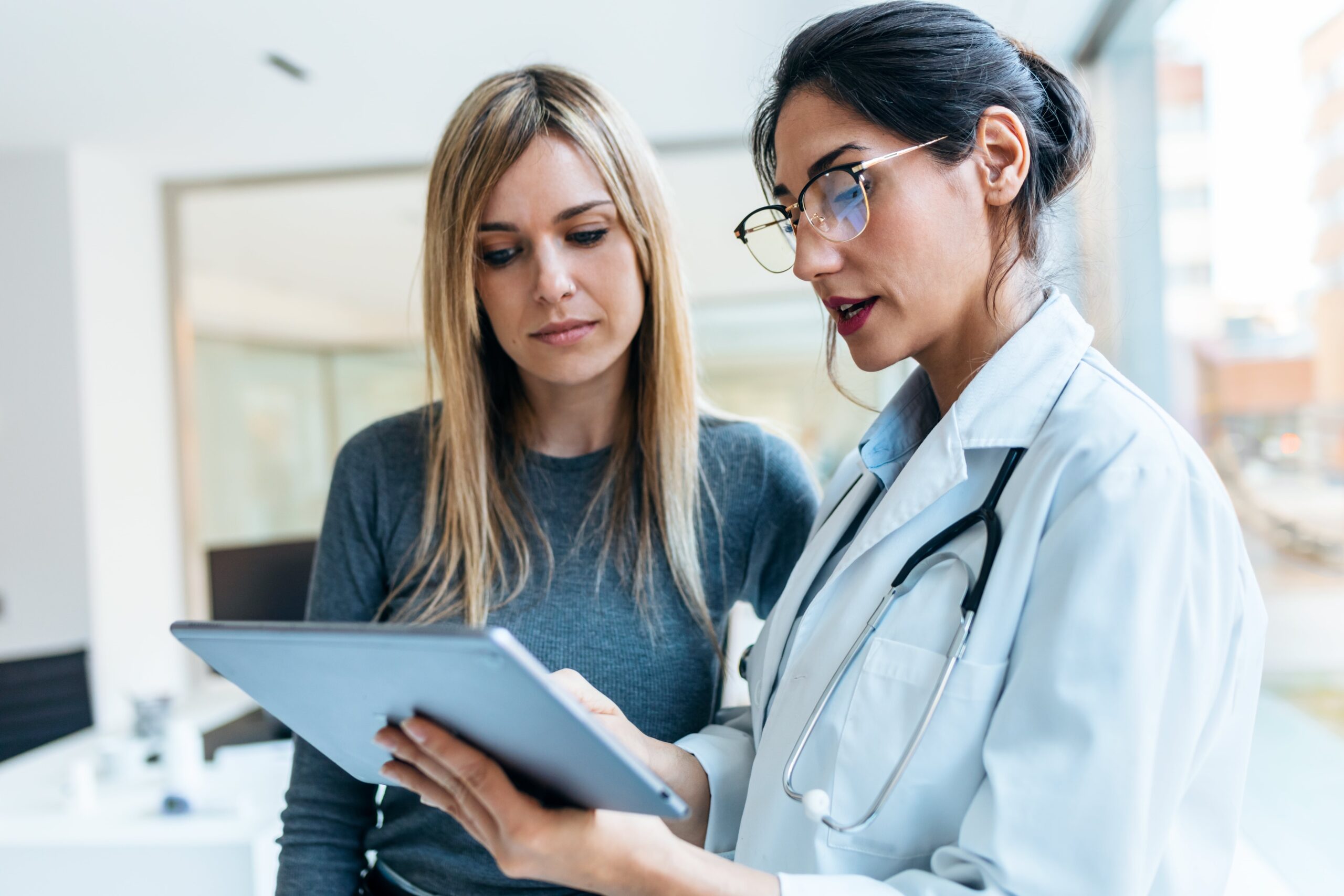 Doctor reviewing OB/GYN imaging on a tablet with a patient
