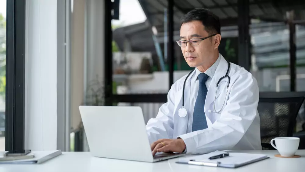 A doctor using a laptop to access cloud-based PACS