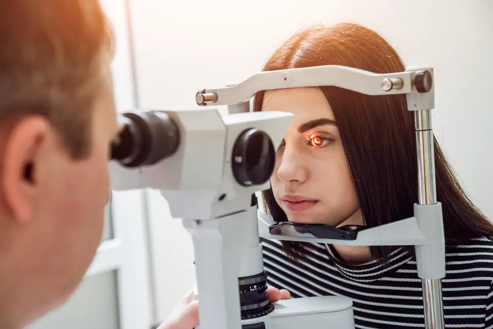 Patient undergoing an eye examination with a slit lamp