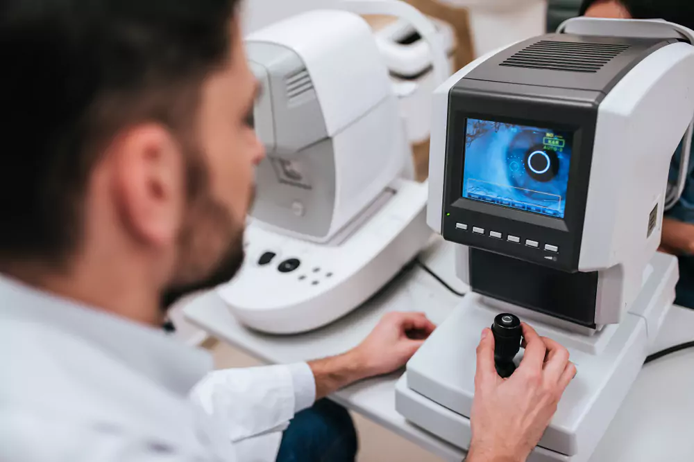 Doctor operating ophthalmology imaging equipment with eye scan display
