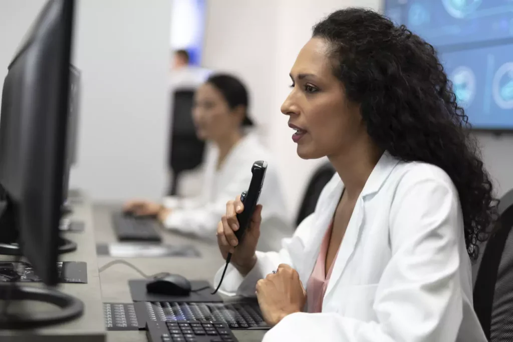 A clinician using a medical dictation device to dictate her report and diagnosis verbally