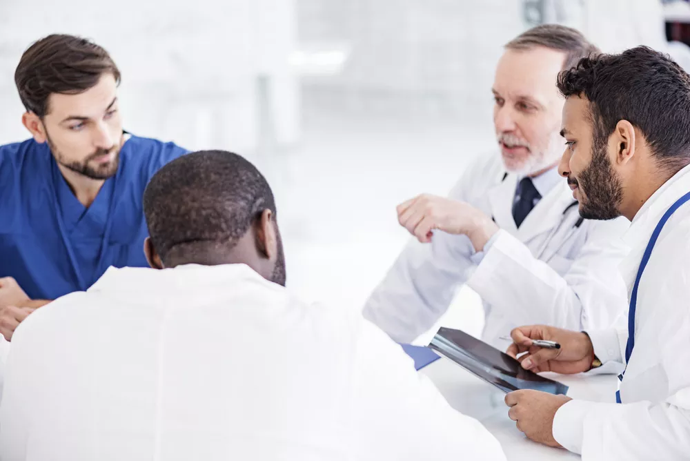 Group of healthcare professionals discussing financial strategies, representing ScImage’s flexible financing solutions